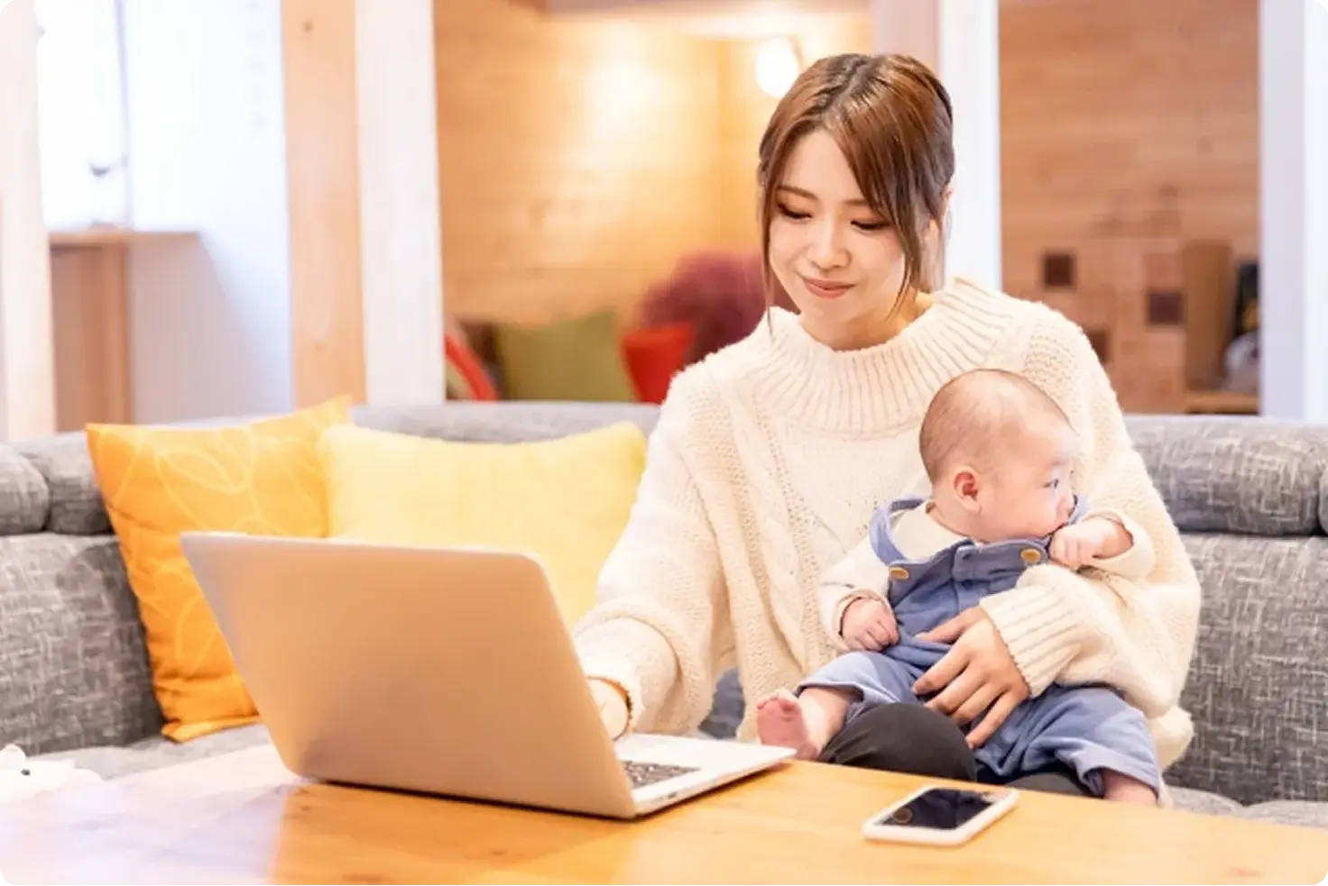 子どもを抱きながら働く女性